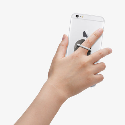 000EP20243 - Style Ring in space gray showing the phone in someone's hand with ring attached to back of device