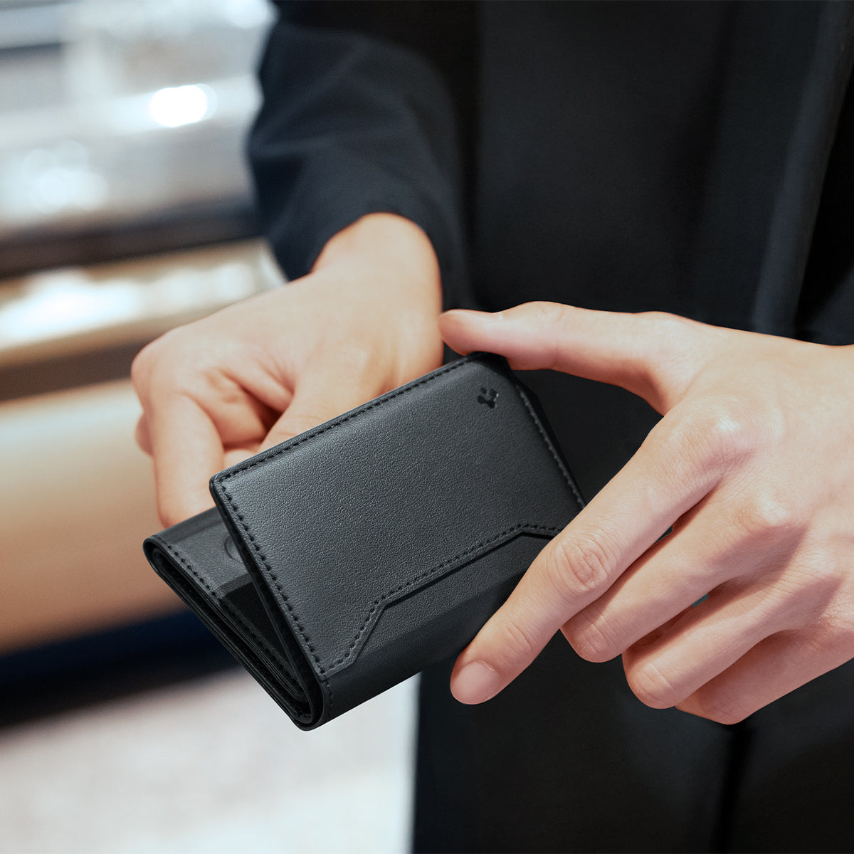 AFA09133 - MagSafe Card Holder Valentinus S (MagFit) in Black showing a man slowly opening the wallet