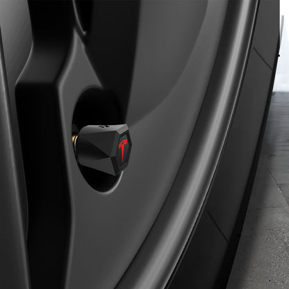 ACP11370 - Universal Tire Valve Stem Cap | VS100TS/R in silver installed on a wheel, featuring a faceted hexagonal design with a red Tesla logo accent.