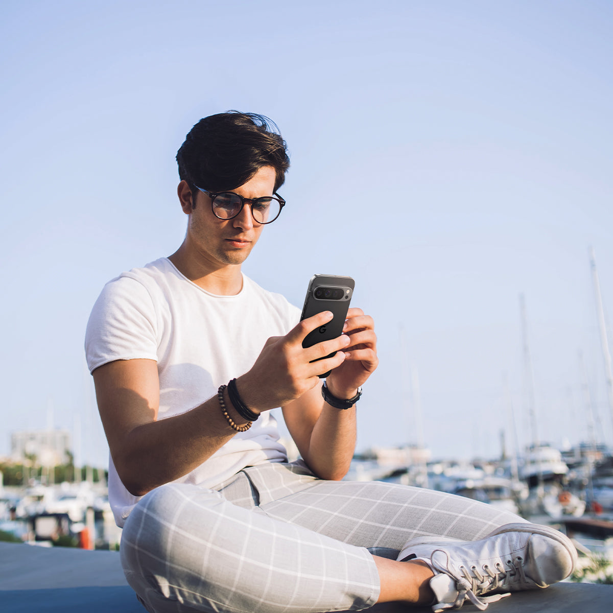 AGL08443 - Pixel 9 Case Optik EZ Fit Lens Protector in Crystal Clear showing a man holding the device with the installed lens protector